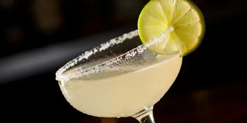 En svalkande margarita med saltkantad glaskant och en limeklyfta, redo att avnjutas mellan lakanen.