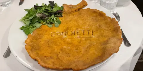 Cosa mangiare a Milano? Una cotoletta gigante con insalata fresca, un classico da provare assolutamente!