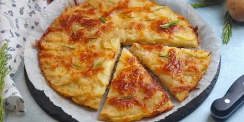 Una deliziosa torta di patate dorata e croccante, guarnita con rosmarino fresco. Perfetta per ogni occasione.