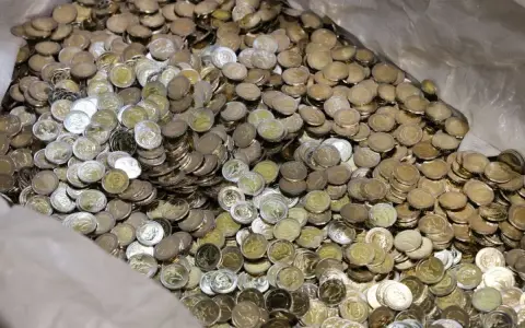 Ogromna ilość monet, prawdopodobnie bułgarska waluta, wypełnia worek.