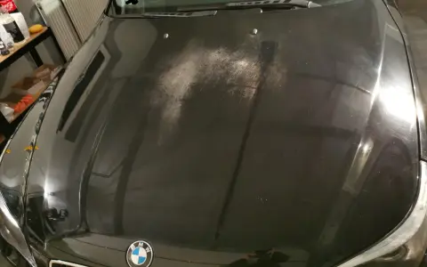 Na czarnej masce BMW widać liczne drobne rysy i zmatowienia, tworzące efekt "oczek na lakierze".