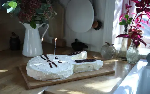 En gitarrformad tårta med vit frosting och chokladdekorationer, perfekt för alla musikälskare. En av många tårt ideer för en speciell dag.