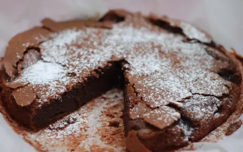 En saftig kladdkaka, pudrad med florsocker, redo att avnjutas. Perfekt för fikat eller som en del av ett dessertbord med andra kladdkaka kakor.