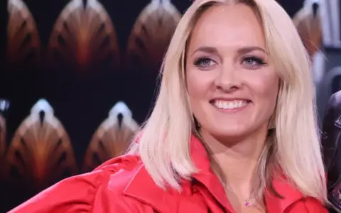 Uśmiechnięta Ola Radwan w czerwonej marynarce, gotowa do zgadywania w "Jaka to melodia?".