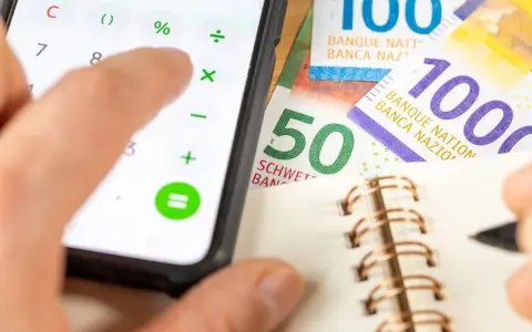 Rechnung für das Kostgeld der Kinder: Ein Handy mit Taschenrechner, Schweizer Franken und ein Notizbuch.