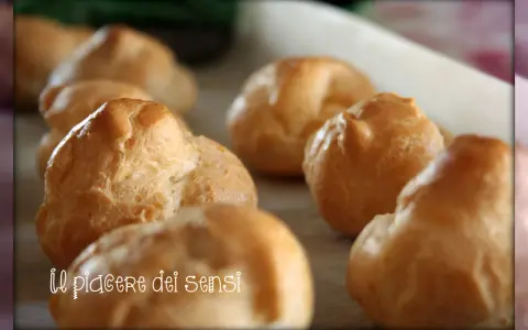 Bignè alla crema dorati e soffici, pronti per essere gustati. Un vero piacere per i sensi.