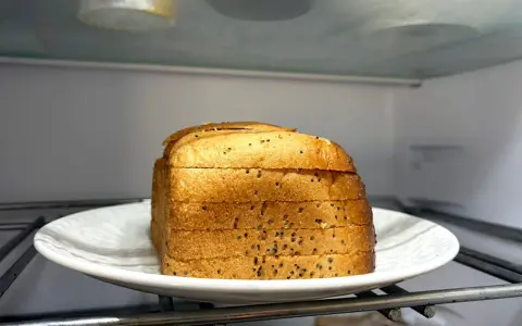 Kromki chleba na talerzu w lodówce. Czy można trzymać chleb w lodówce? To pytanie nurtuje wielu.