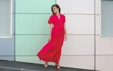 Elegancka kobieta w czerwonej sukience maxi, idealna odpowiedź na pytanie "w co się ubrać na wesele po 40".