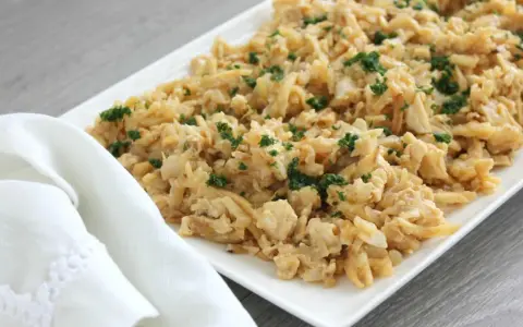 Delicioso plato de migas de bacalao desmenuzado, salteado y espolvoreado con perejil fresco.