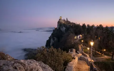 Torre Guaita domina la nebbia al tramonto, un luogo magico dove si trova San Marino.