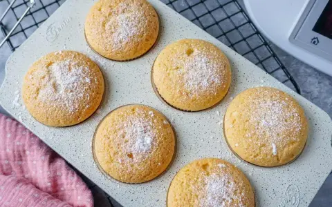 Sechs goldbraune Muffins, mit Puderzucker bestäubt, warten auf ihre Verkostung. Perfekt aus dem Thermomix!