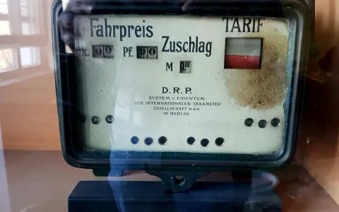 Altes Taxameter mit "Fahrpreis" und "Zuschlag" Anzeige. Der Tarif ist auf 0,90 Mark eingestellt.