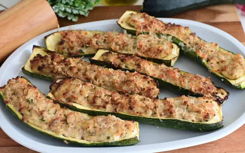 Zucchine ripiene in padella, dorate e gratinate, pronte per essere gustate.