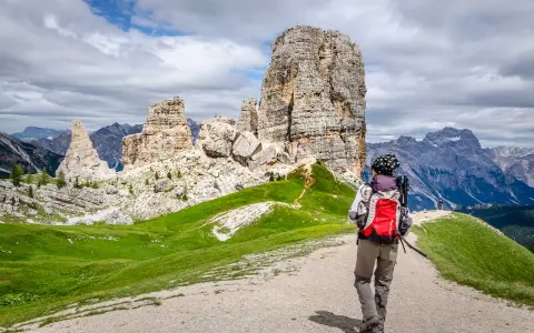 Wanderer auf einer **Cinque Torri Wanderung** mit Blick auf die markanten Felsformationen und die Dolomiten.