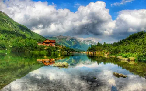 Piękne tatry słowackie z dziećmi nad jeziorem. Chata odbija się w spokojnej tafli wody, a góry otaczają malowniczy krajobraz.