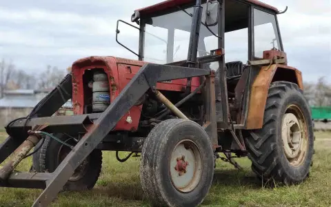Czerwony traktor Ursus C-360 z ładowaczem. Zbiornik paliwa C-360 pojemność jest kluczowa dla długiej pracy w polu.