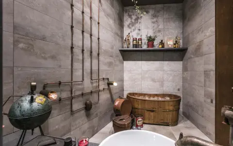 Ambiance unique dans cette salle de bain industrielle avec baignoire en bois, tuyauterie apparente et lampes vintage.