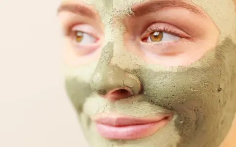 Primo piano di un viso con maschera all'argilla verde. Scopri a cosa serve l'argilla verde per la tua pelle.