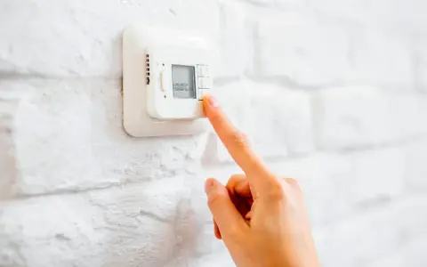 Ajustando el termostato para unos agradables grados calefaccion invierno.