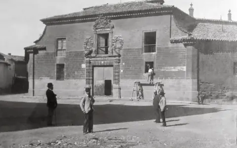 Hombres observan una casa señorial, un ejemplo de la arquitectura de la ilustración en España.