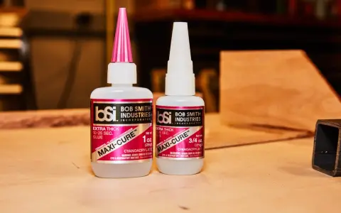 Two bottles of Bob Smith Industries Maxi-Cure glue, explaining why super glue is so strong due to its cyanoacrylate formula.