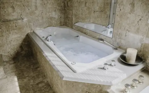 Baignoire balnéo avec jets d'eau bouillonnante, ambiance spa relaxante. Avis positif pour ce moment de détente.