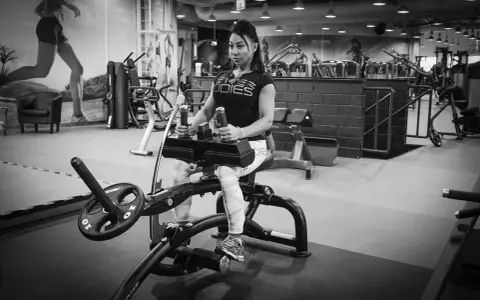 Kvinna tränar sittande vadpress på gym.