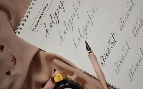Eleganckie akcesoria do kaligrafii: pióro, tusz i zeszyt z ćwiczeniami, idealne do ręcznego adresowania kopert.