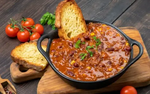 Gęste chili con carne z fasolą i kukurydzą, podane z chrupiącym pieczywem. Idealny obiad na dwa dni, który rozgrzeje i nasyci.
