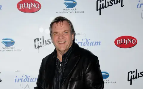 Meat Loaf lächelt in die Kamera, bereit, alles für die Liebe zu tun. Hinter ihm sind Logos von Rhino, Gibson und Eagle Rock Entertainment zu sehen.