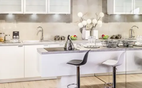 Nowoczesna kuchnia w stylu glamour: inspiracje dla eleganckiego wnętrza. Białe meble, chromowane dodatki i subtelne dekoracje tworzą luksusową atmosferę.