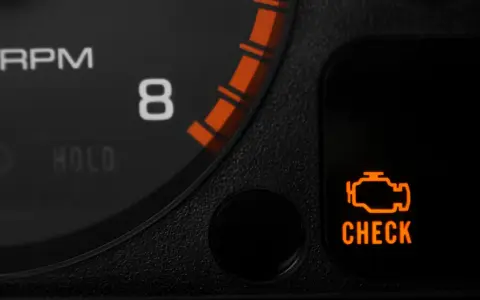 Pomarańczowa kontrolka "check engine" świeci się na desce rozdzielczej Audi A3 8P, sygnalizując problem z silnikiem.