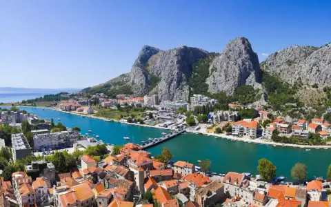 Widok na miasto Omis w Chorwacji z rzeką Cetina i górami w tle.