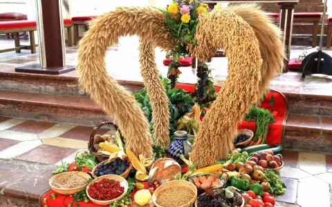 Erntedankfest: Herz aus Getreide mit Früchten, Gemüse und Brot.