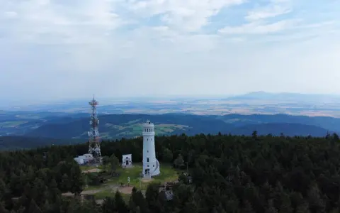 Widok z góry na wieżę widokową i maszt telekomunikacyjny pośród lasu. Którym szlakiem dotarła tu wielka sowa?