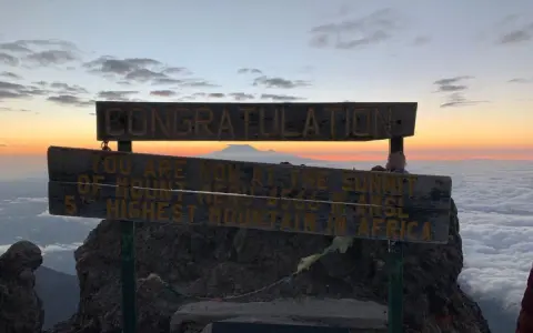 Gratulacje! Jesteś na szczycie Mount Meru, 5. najwyższej góry Afryki. Widok na morze chmur i wschód słońca zapiera dech w piersiach.