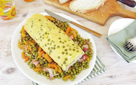 Rotolo di frittata dorato adagiato su un letto di piselli e carote. Un piatto semplice e gustoso, perfetto per un pasto leggero.