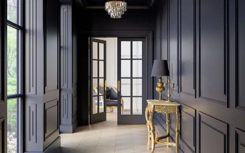 Elegancja w ciemnym korytarzu. Złota konsola z lampą i świecznikiem, kryształowy żyrandol, dwuskrzydłowe drzwi. Korytarz inspiracje.