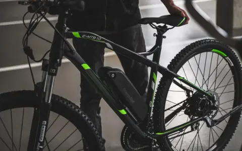 Czarny rower elektryczny z zielonymi akcentami i baterią Green Cell. Dowiedz się, jak sprawdzić baterię w rowerze elektrycznym.