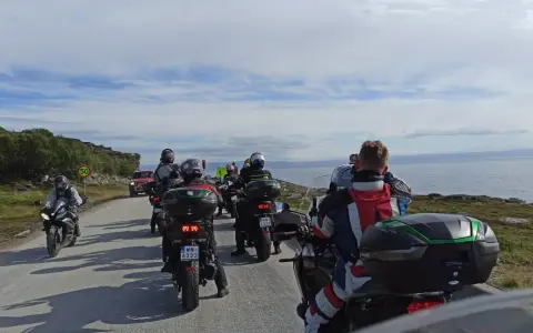 Motocykliści jadący w kierunku Nordkapp w Norwegii, podziwiając malownicze krajobrazy wybrzeża.