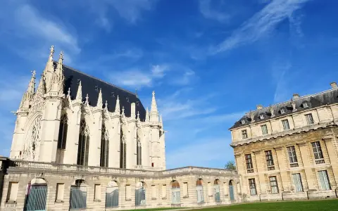 El castillo de Vincennes, con su imponente arquitectura gótica y clásica, se alza bajo un cielo azul vibrante.