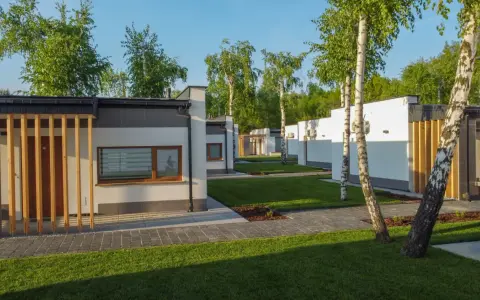Nowoczesne domki na riviera camp otoczone zielenią i drzewami.