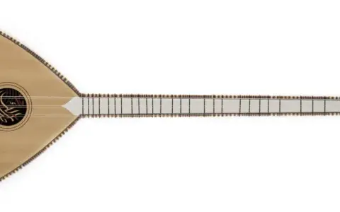 Un bouzouki en bois clair, orné d'une découpe en forme de piment, prêt à faire vibrer ses cordes.