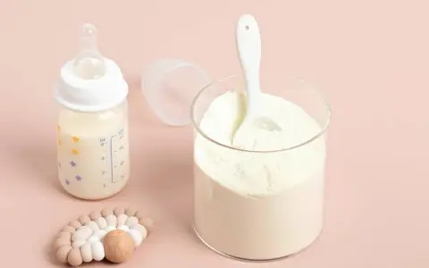 Słoik z mlekiem w proszku i butelka z mlekiem. Pediatrzy często polecają odpowiednie mleko początkowe dla niemowląt.
