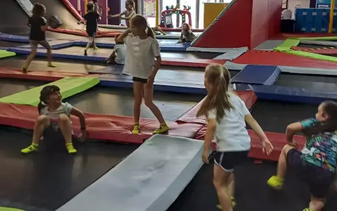 Dzieci skaczą na trampolinach w parku rozrywki. To świetne gorzów wielkopolski atrakcje dla dzieci, pełne radości i ruchu.