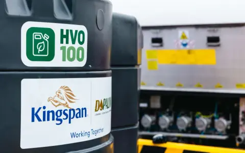 Zbiornik z ekologicznym paliwem HVO 100, obok logo Kingspan. Nowoczesne rozwiązanie dla transportu.