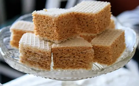 Słodkie wafle z mlekiem w proszku, ułożone na szklanej paterze. Idealne na deser.