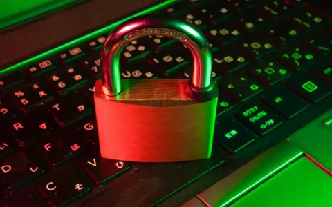 Un cadenas sur un clavier d'ordinateur, symbolisant la **sécurité informatique**. La lumière rouge et verte crée une ambiance de protection numérique.
