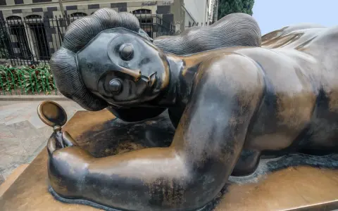Sculpture d'une femme en bronze, tenant un miroir, évoquant les sculpteurs français contemporains connus.