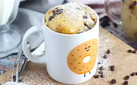 Delicioso bizcocho a la taza con chispas de chocolate, espolvoreado con azúcar glas. ¡Perfecto para un antojo rápido!